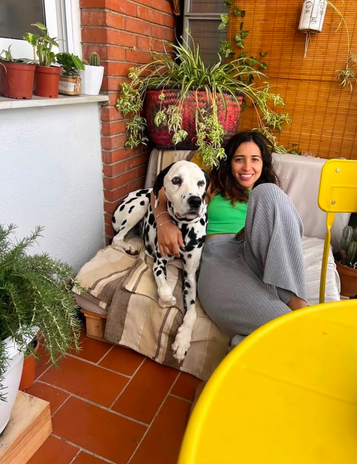 Mariana et un dalmatien détendus sur une terrasse pleine de plantes, comme à la maison, pendant l’hébergement à Barcelone