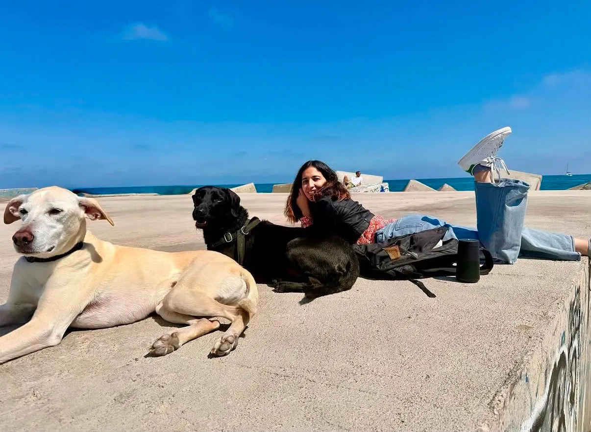 Mariana, gardienne de Marcando Huella, au bord de la mer à Barcelone avec deux chiens détendus et heureux