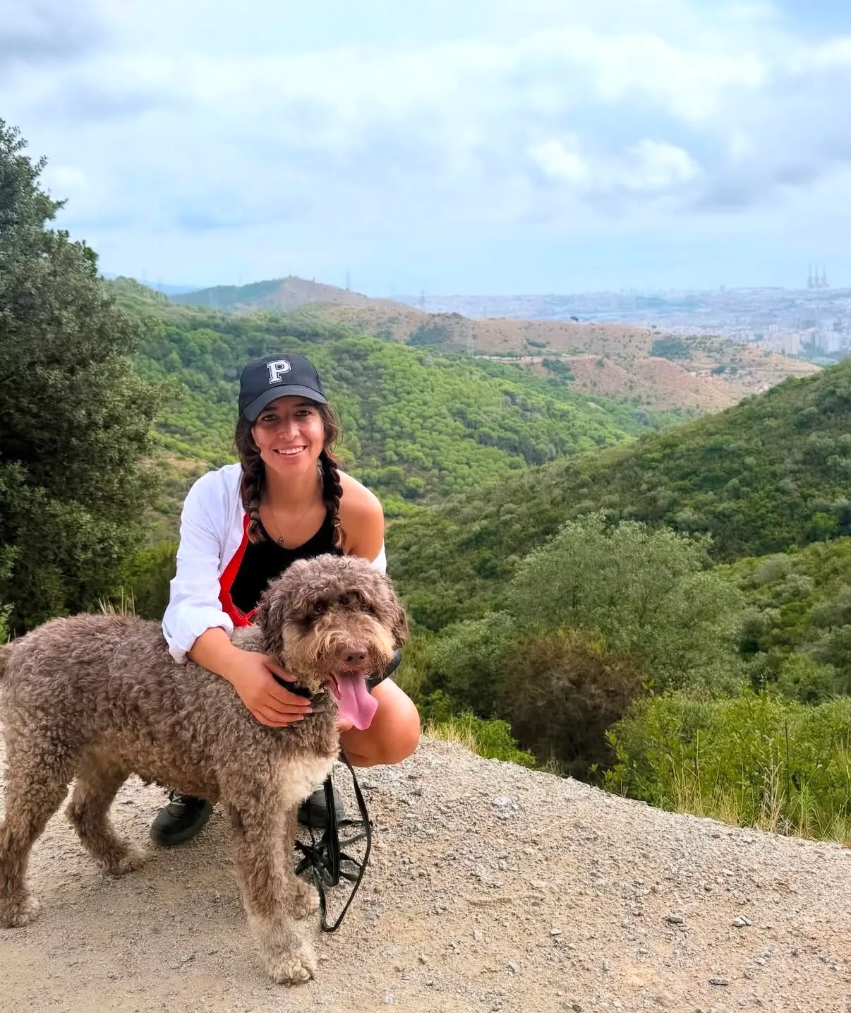 Mariana enlaçant un chien d'eau dans les collines de Collserola avec Barcelone en arrière-plan